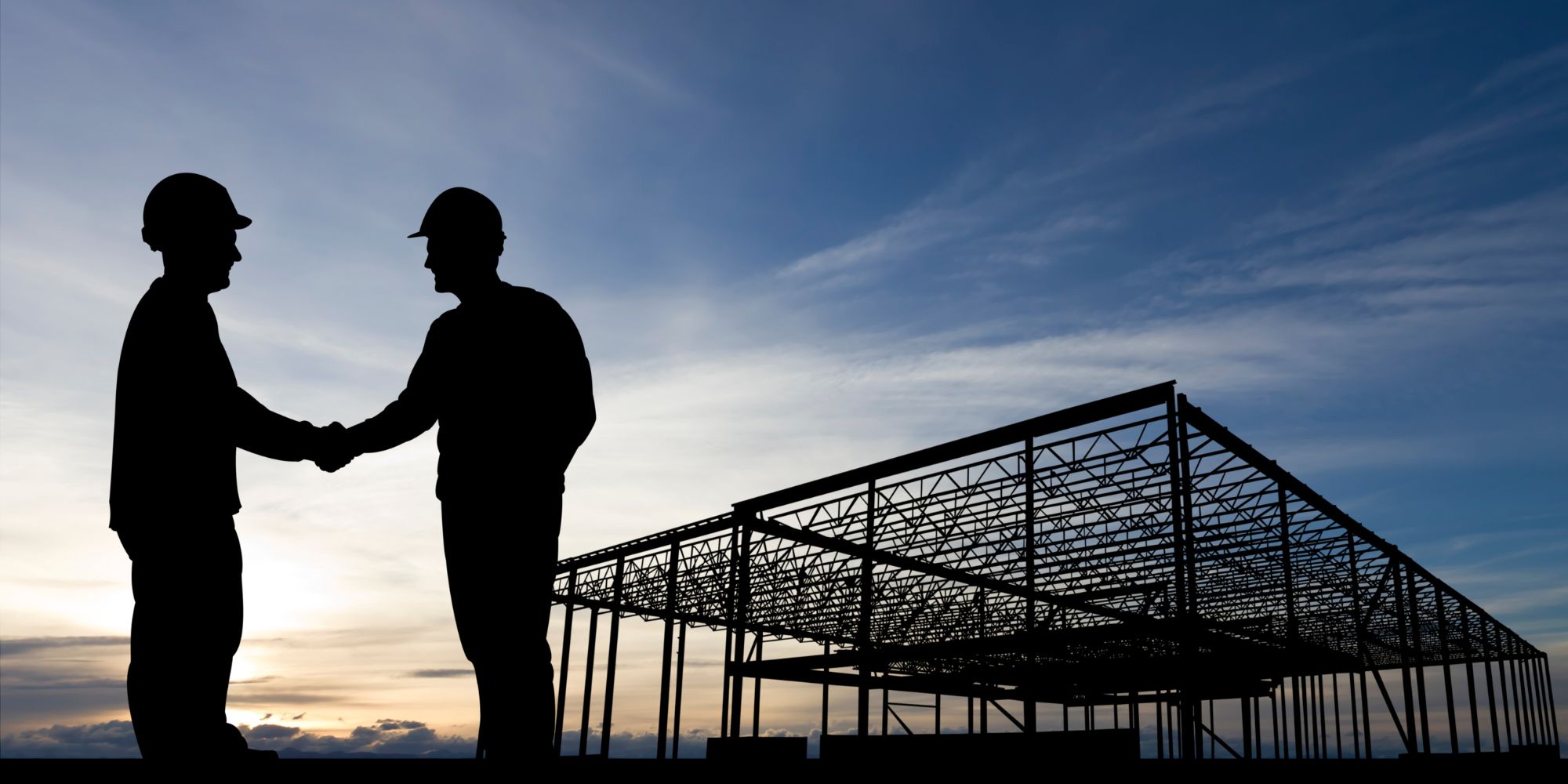 FBS nor din totalleverandør av stålhall Siluetten av to personer som inngår en avtale foran en stålhall.
